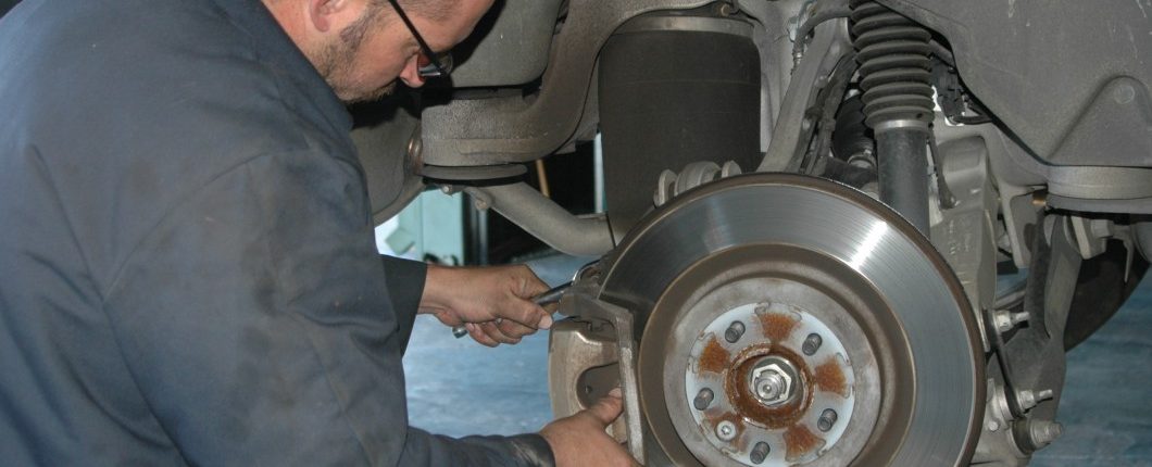 Image of mechanic check the brake pads and rotors and repairing at Ross Tire & Service