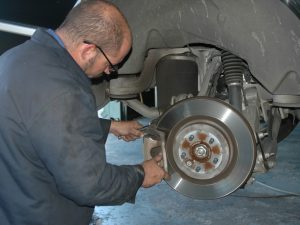 Image of mechanic check the brake pads and rotors and repairing at Ross Tire & Service