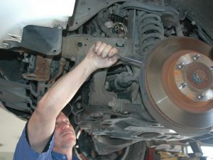 Image of a mechanic repair the front end suspension on a vehicle at Ross Tire & Service in Lafayette, LA