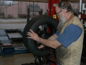 Image of a technician repairing on a flat tire caused by a nail in the tire at Ross Tire in Lafayette, LA